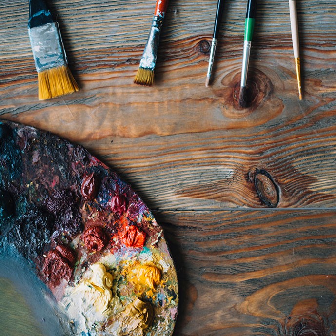 تصویر استوک قلموها و پالت رنگ در زمینه چوبی