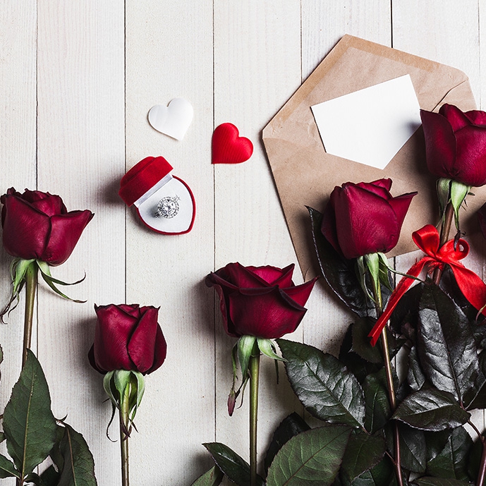 عکس با کیفیت گل‌های رز در کنار حلقه ازدواج و نامه عاشقانه