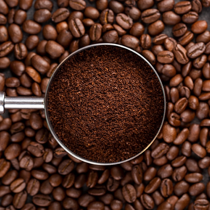 عکس با کیفیت پودر قهوه در زمینه دانه‌های قهوه